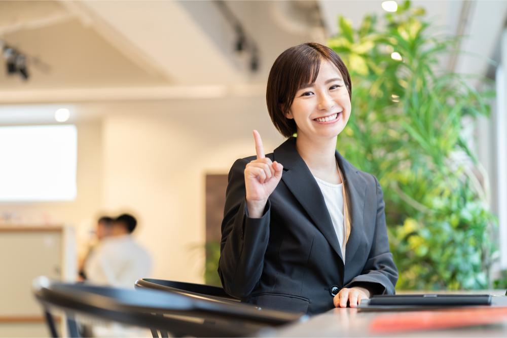 人差し指を立ておすすめする女性